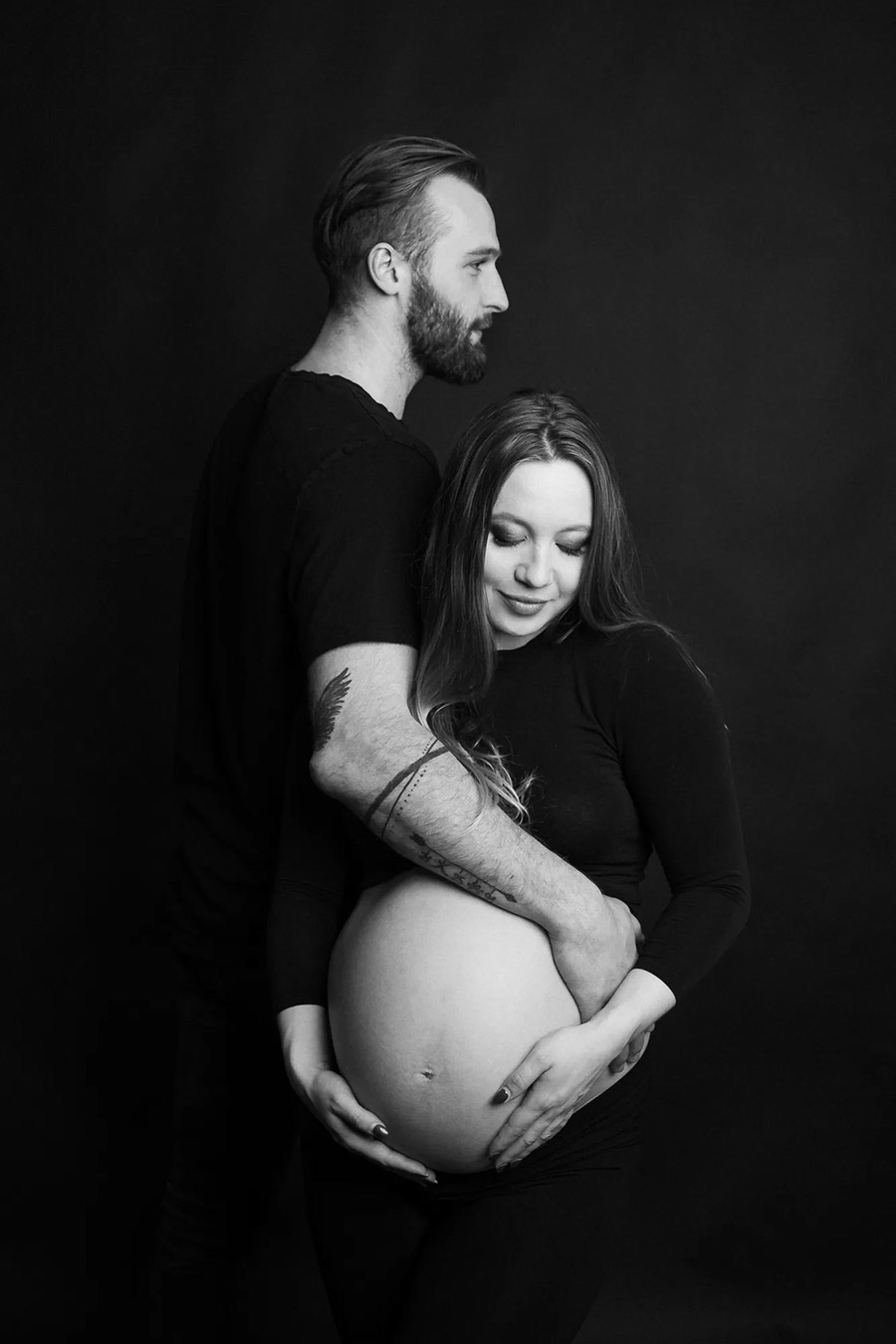 Profesionální černobílý portrét páru, zachycující jejich přirozenou blízkost.